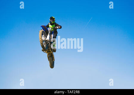 Motocross driver jumping in blue sky Stock Photo