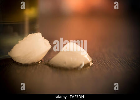 A close-up photo of ice cubes on a wooden table Stock Photo