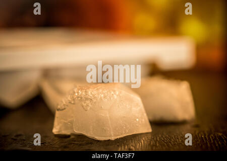 A close-up photo of ice cubes on a wooden table Stock Photo