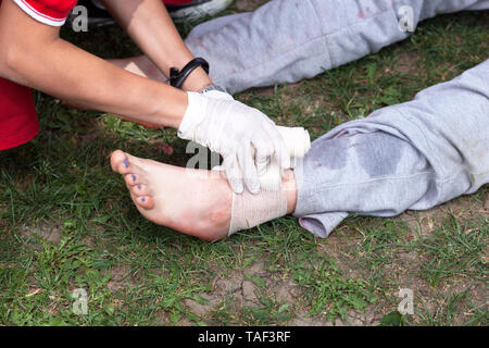 First aid training with demonstration of leg injury treatment Stock Photo