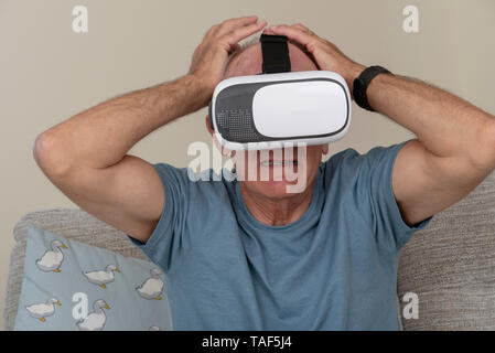 Portsmouth UK, May 2019. Elderly man having fun and frights wearing a pair of virtual reality goggles Stock Photo