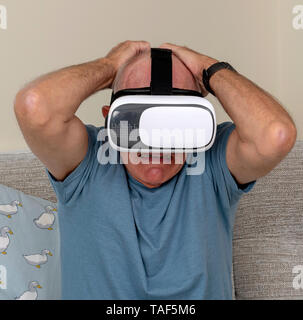 Portsmouth UK, May 2019. Elderly man having fun and frights wearing a pair of virtual reality goggles Stock Photo