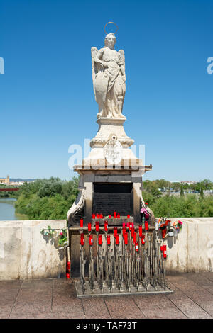 Religious statue with a halo and red candles below on the restored and strengthened roman bridge, Cordoba, Andalusia region, Spain Stock Photo