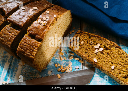 homemade corn bread slices on a blue wooden table with oat flakes Stock Photo