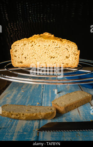 slices of homemade corn bread on a blue wooden table and on a stainless steel grill Stock Photo