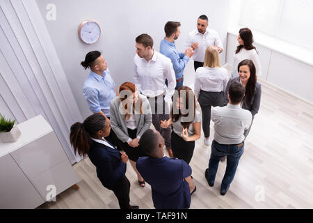 Professional Diverse Businesspeople Discussing With Each Other In Corporate Office Stock Photo
