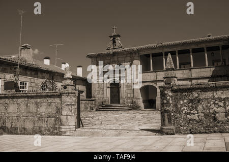 Stone walled fence with gateway in front of old building and deserted alley at Guarda. A well-kept medieval town in the eastern Portugal. Stock Photo