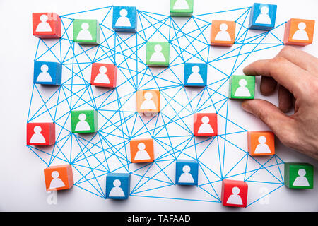 Person's Hand Holding Connecting Icon People Wooden Cube Block For Social Media Networking Stock Photo