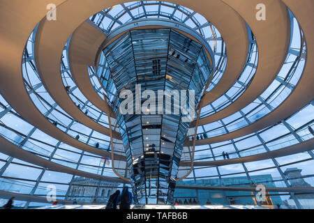 Tourists inside the futuristic glass dome on top of the Reichstag (German parliament) building in Berlin, Germany, in the evening. Stock Photo