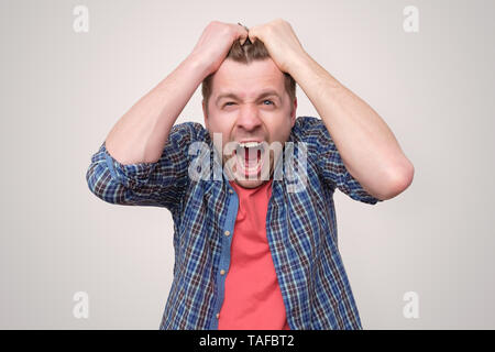Furious, enraged man with mouth opened in shout Stock Photo