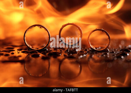 beautiful wedding rings on fire with reflection and in water Stock Photo