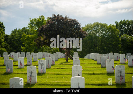 Arlington, VA, USA. 23rd May, 2019. Soldiers assigned to the 3d U.S. Infantry Regiment (The Old Guard) place US flags on graves at Arlington National Cemetery on May 24, 2018 ahead of Memorial Day in Arlington, Virginia. Credit: Michael A. McCoy/ZUMA Wire/Alamy Live News Stock Photo