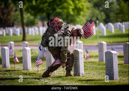 Arlington, VA, USA. 23rd May, 2019. Soldiers assigned to the 3d U.S. Infantry Regiment (The Old Guard) place US flags on graves at Arlington National Cemetery on May 24, 2018 ahead of Memorial Day in Arlington, Virginia. Credit: Michael A. McCoy/ZUMA Wire/Alamy Live News Stock Photo