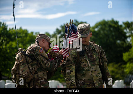 Arlington, VA, USA. 23rd May, 2019. Soldiers assigned to the 3d U.S. Infantry Regiment (The Old Guard) place US flags on graves at Arlington National Cemetery on May 24, 2018 ahead of Memorial Day in Arlington, Virginia. Credit: Michael A. McCoy/ZUMA Wire/Alamy Live News Stock Photo