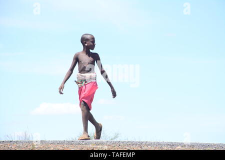Kenya. 21st May, 2019. A young boy seen walking on the Great North Road also known as the Cape to Cairo Road.The road runs through the arid parts of the Northern Kenya connecting with Ethiopia. Its tarmacking was fully completed recently and it's expected to open up the region's economic potential. Credit: Allan Muturi/SOPA Images/ZUMA Wire/Alamy Live News Stock Photo