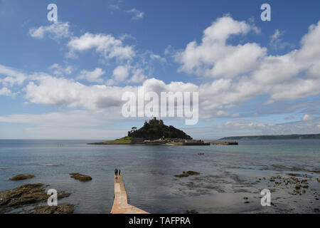 Marazion, Cornwall, UK. 25th May 2019. UK Weather. Despite the sunny hot weather it was a quiet start to the bank holiday weekend at Marazion, with a handful of people wading across the walkway to St Michaels Mount. Credit Simon Maycock / Alamy Live News. Stock Photo