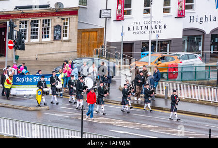 Inverness, Scottish Highlands, Scotland, United Kingdom, 25th May 2019: A marching Scottish pipe band with bagpipes and drums leads the fourth annual anti-stigma walk for mental health organised by Birchwood Highland along the riverbank of River Ness and across the Ness Bridge into the city centre. The event is part of the Scottish Mental Health Arts Festival Stock Photo