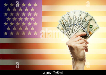 People raising hands dollars and American flag on background. Patriotic concept Stock Photo