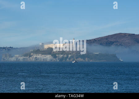 SAN FRANCISCO, CALIFORNIA, UNITED STATES - NOV 25th, 2018: Alcatraz prison in fog panorama during a sunny day in November as seen from pier 39 Stock Photo