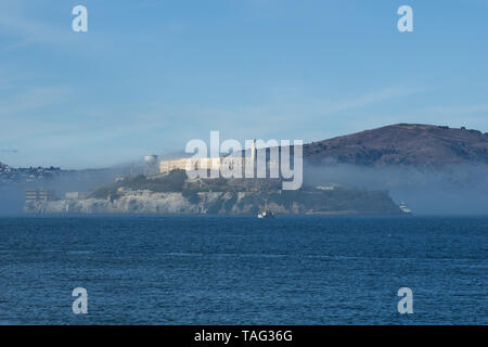 SAN FRANCISCO, CALIFORNIA, UNITED STATES - NOV 25th, 2018: Alcatraz prison in fog panorama during a sunny day in November as seen from pier 39 Stock Photo