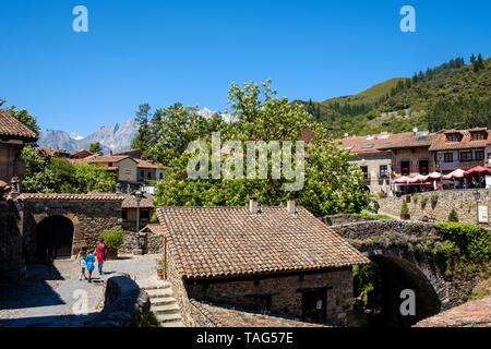 People going to cross the San Cayetano Bridge on the Historic Old Town of Potes, Cantabria, Spain Stock Photo