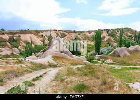 Dirt road leading through the landscape of ancient canyons and abandoned caves of Cappadocia Stock Photo