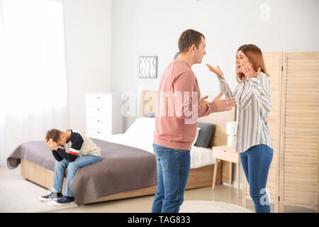 Sad little boy with his quarreling parents at home Stock Photo