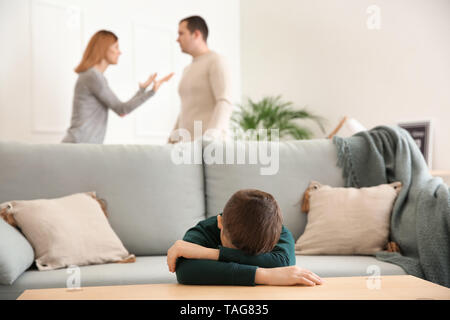 Sad little boy with his quarreling parents at home Stock Photo