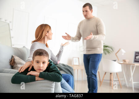 Sad little boy with his quarreling parents at home Stock Photo