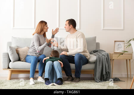 Sad little boy with his quarreling parents at home Stock Photo