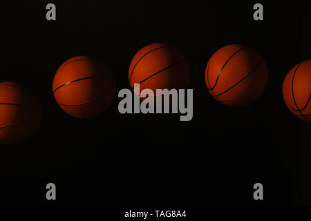 Stroboscopic photo of moving ball on dark background Stock Photo