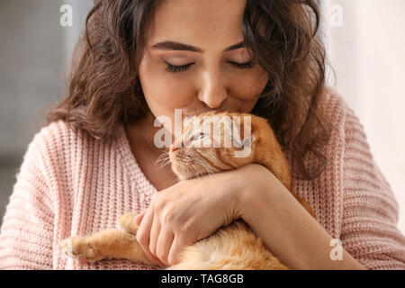 Young woman with cute funny cat at home Stock Photo