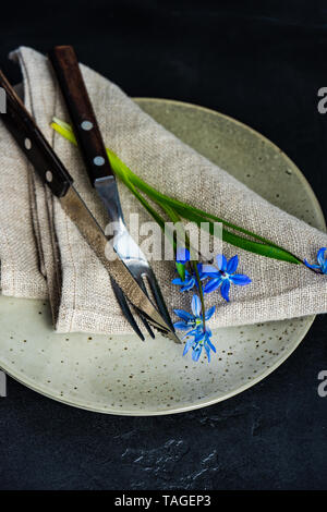 Spring table setting with blue scilla siberica flowers on concrete background with copy space Stock Photo