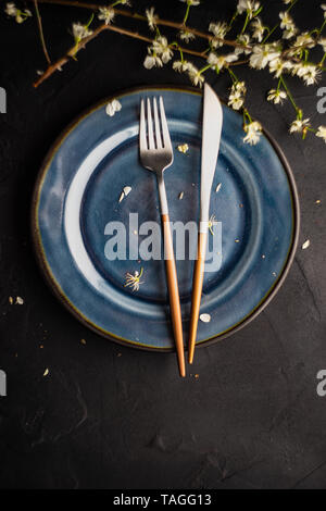 Spring table setting with peach blooming tree branch on wooden background with copy space Stock Photo