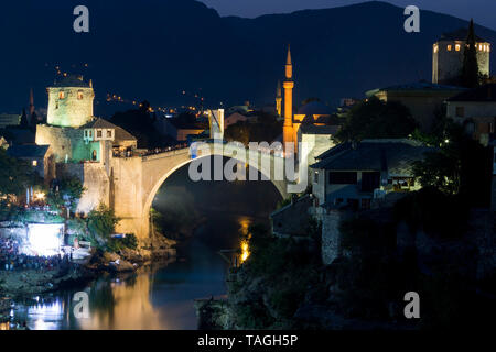 MOSTAR, BOSNIA AND HERZEGOVINA - AUGUST 13, 2015: Night photo of Tourist and locals walking near Old bridge in Mostar. Stock Photo