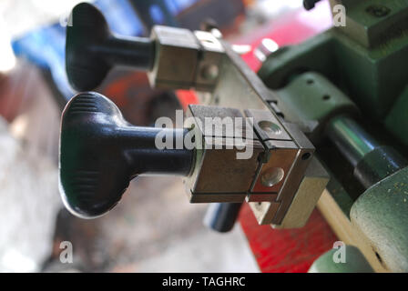 The small metal handle of the metal cutter serves to move the metal toward the metal cutting blade. Stock Photo
