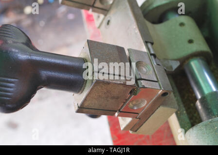 The small metal handle of the metal cutter serves to move the metal toward the metal cutting blade. Stock Photo