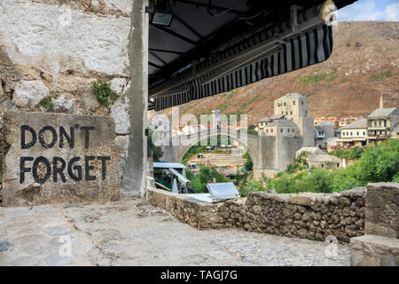 Don't forget sign in Mostar with blurred Old bridge in distance. Sunrise photo Stock Photo