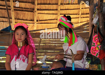 LONGNECK KAREN VILLAGE, THAILAND - DECEMBER 17. 2017: Two girls from long neck tribe playing in the hut Stock Photo