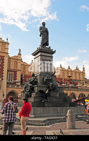 Visitors at the statue of Adam Mickiewicz.  Main Market Square, Krakow.  Old city.  Rynek Glowny. Stock Photo