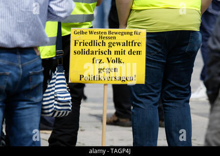 Wiesbaden, Germany. 25th May 2019. A sign reading 'Yellow vests movement of Hesse - peaceful, without violence, solidaric with the French people against the failure of politics' stands on the ground. Under 100 right wing protesters marched with yellow vests through Wiesbaden, to protest against the German government. They were confronted by small but loud counter protest. Stock Photo