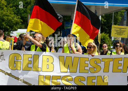 Wiesbaden, Germany. 25th May 2019. The march leads with a banner that reads 'Yellow vests Hesse' and two German flags. Under 100 right wing protesters marched with yellow vests through Wiesbaden, to protest against the German government. They were confronted by small but loud counter protest. Stock Photo
