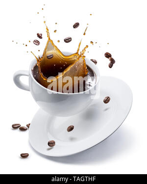 Splash of coffee in white cup and coffee beans in air. Isolated on white. Stock Photo