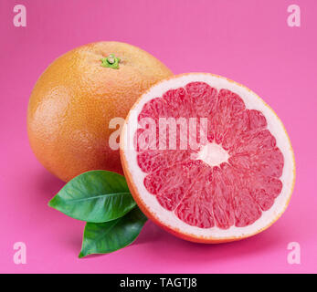 Grapefruit and grapefruit slice isolated on pink background. Stock Photo
