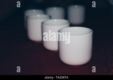 Row of white ceramic tea cup on a table. Selective focus. Copy space. Stock Photo
