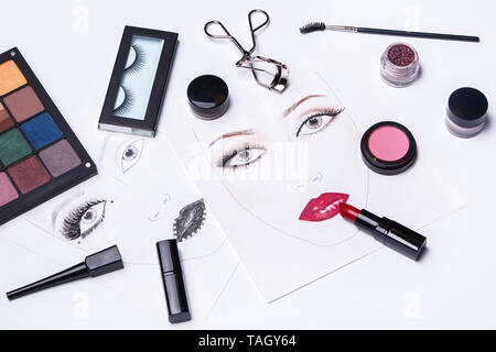 Face charts and different makeup objects and cosmetics on white background Stock Photo