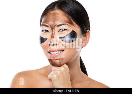 Young asian woman with a purifying peel-off mask on her face over white background Stock Photo