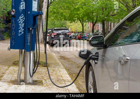 Montreal, CA - 25 May 2019: Chevrolet Volt electric car plugged into an EV charging station. Stock Photo