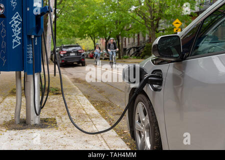 Montreal, CA - 25 May 2019: Chevrolet Volt electric car plugged into an EV charging station. Stock Photo