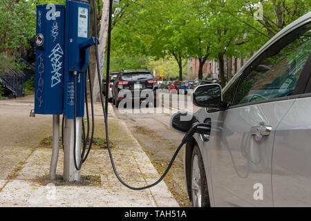 Montreal, CA - 25 May 2019: Chevrolet Volt electric car plugged into an EV charging station. Stock Photo